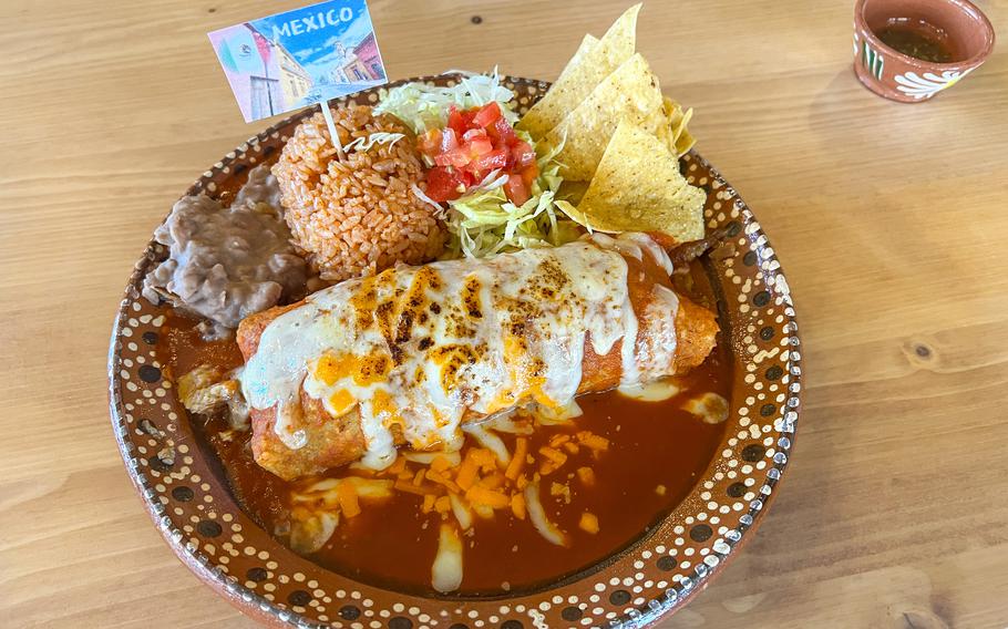 A burrito in a bowl is drowning in sauce.