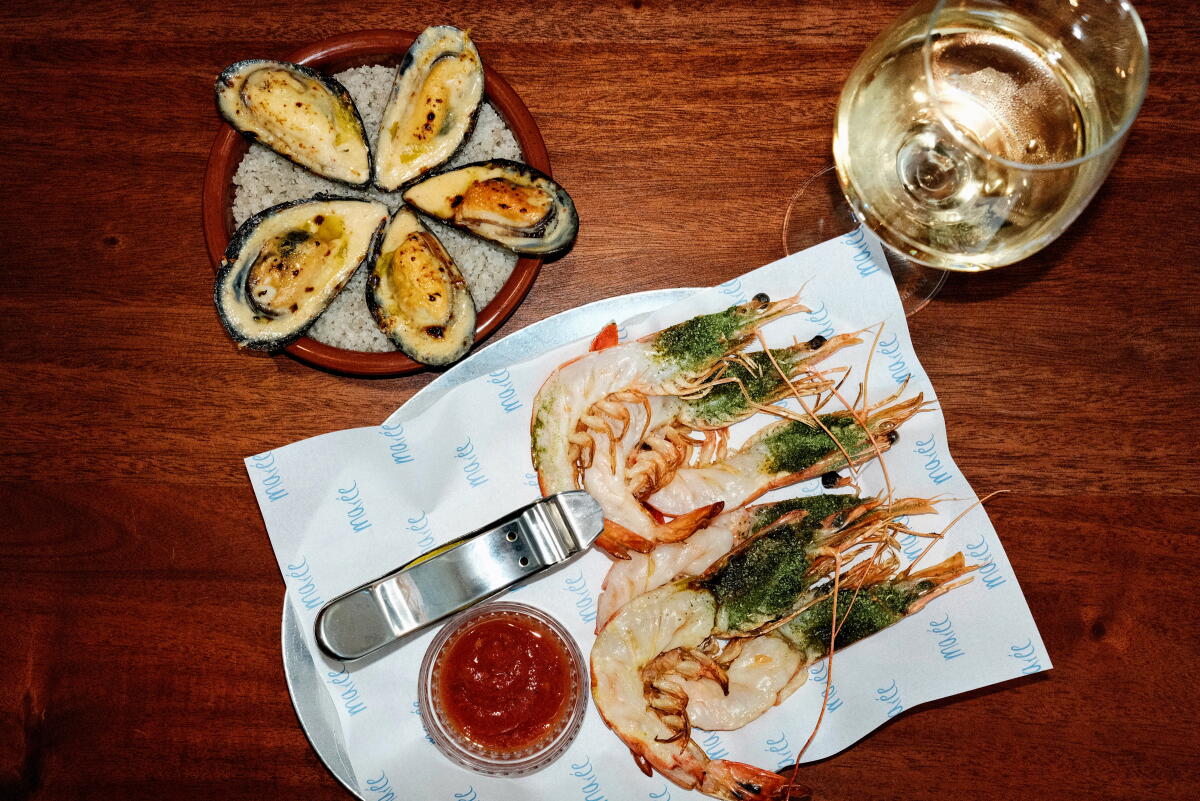 Salt Spring Island mussels "gratin," left, with Caledonian blue prawn cocktail and a glass of wine