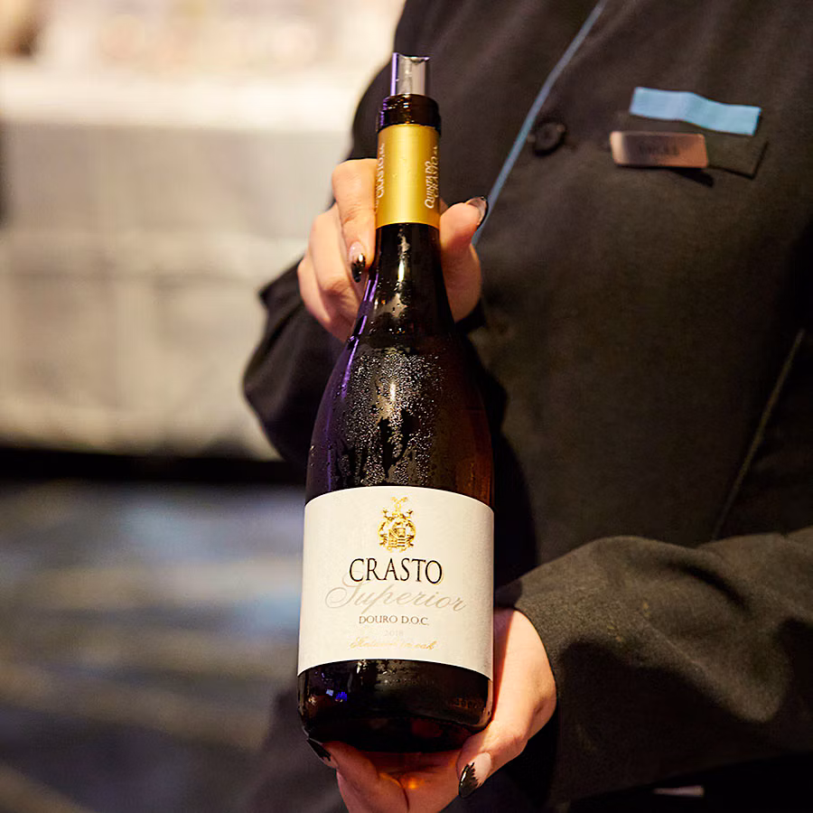  Server holding a bottle of Quinta do Crasto.