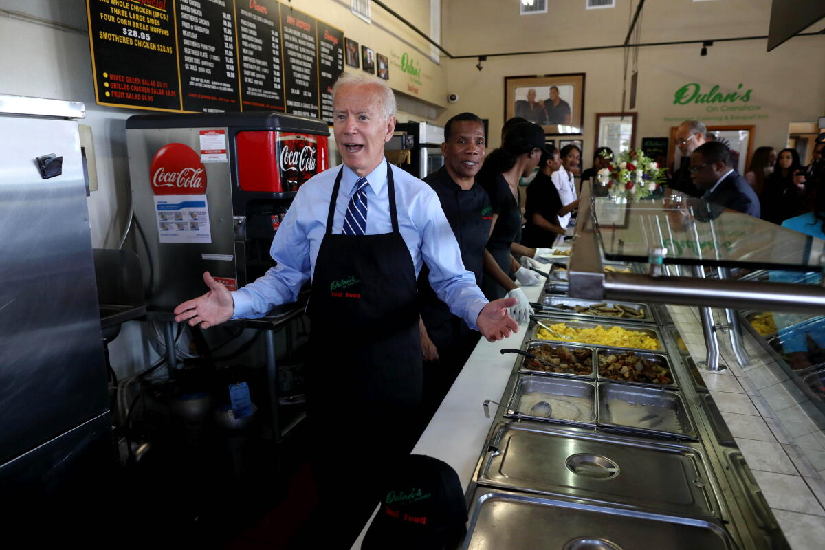 LOS ANGELES, CALIF. -- THURSDAY, JULY 18, 2019: Former Vice President Joe Biden, a Democratic presidential hopeful, shown with owner Greg Dulan, right, serves breakfast to constituents at Dulans On Crenshaw Soul Food Restaurant, in Los Angeles, Calif., on July 18, 2019. 
