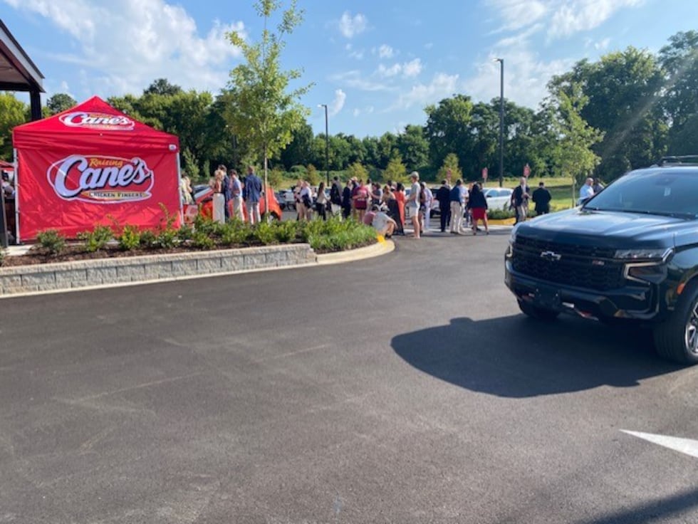 Tuscaloosa city leaders and community leaders cut the ribbon on Raising Cane's Chicken diner...