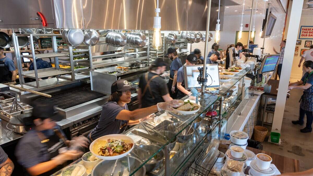 Chefs, line cooks, and trainees swiftly navigate the front counter station at the new Flower Child restaurant on Friday, Aug. 7, 2026. Chefs, line cooks, and trainees swiftly navigate the front counter station at the new Flower Child restaurant on Friday, Aug. 7, 2026.