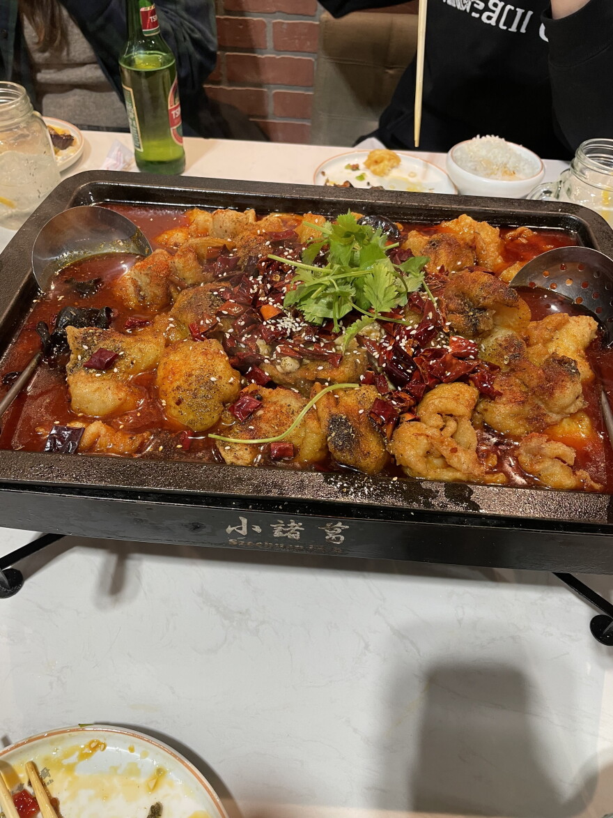 Friends share a full vat of spicy, tingling, numbing sichuan fish with sides