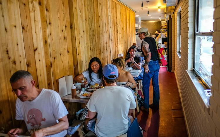 Customers sitting at tables eating at Kirbee's BBQ.