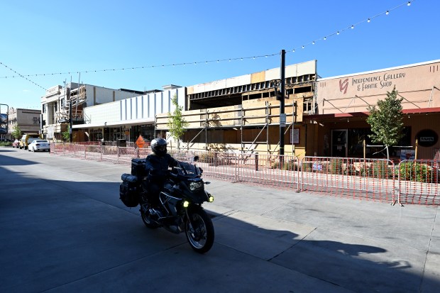 A motorcyclist passes by a building at 225 east Fourth Street Thursday, Oct. 2, 2026, where the roof collapsed after a construction crew hit a support beam with machinery on Wednesday afternoon in downtown Loveland. (Jenny Sparks/Loveland Reporter-Herald)