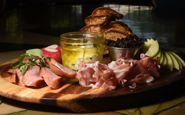 Shuga's Restaurant "Mully's Snack Board" - herb marinated goat cheese, jar salami, prosciutto, radish n salt, apple, strawberries, grilled pita and toast Wednesday July 13, 2016. Photo by Jeff Kearney.
