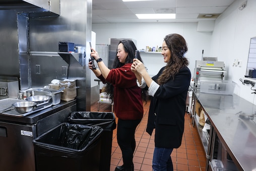 Kimberly Kong and videographer Minje Suh film an Instagram video in the kitchen at Bao Bei, a Taiwanese street food eatery in Rockville, Md.