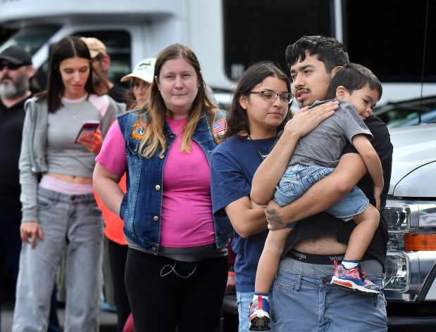 Ruben and Selena Niaves comfort their son Anastacio, 2, while waiting in line for the Meals on Wheels of Northwest Indiana storm relief meal distribution event at Porter County Aging & Community Services in Valparaiso, Indiana, Tuesday, September 22, 2026. The couple travelled from Portage to get meals, vegetables and other supplies. (Andy Lavalley/for the Post-Tribune)