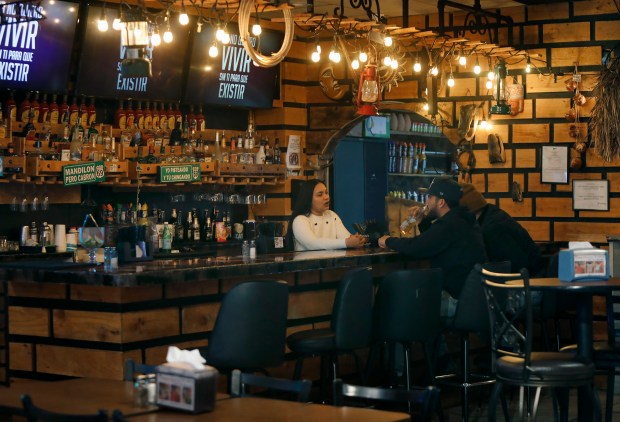 Los Cuates Taqueria bartender Nasly Escorcia chats with their only two customers at lunchtime Tuesday, January 27, 2026. (Stephen M. Katz / The Virginian-Pilot)