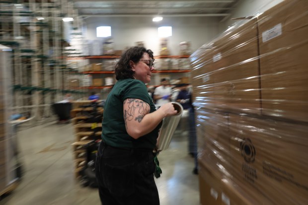 Sierra Helsing, senior manager of volunteer and guest experience, wraps boxes of repacked foods with plastic during an afternoon volunteer session at the Greater Chicago Food Depository on Sept. 11, 2026. (John J. Kim/Chicago Tribune)