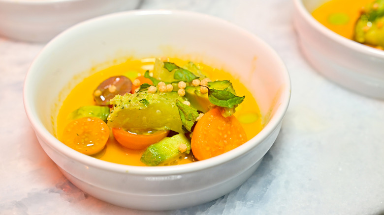 Bright yellow and orange colors of Dōgon restaurant's piri piri salad in white bowl