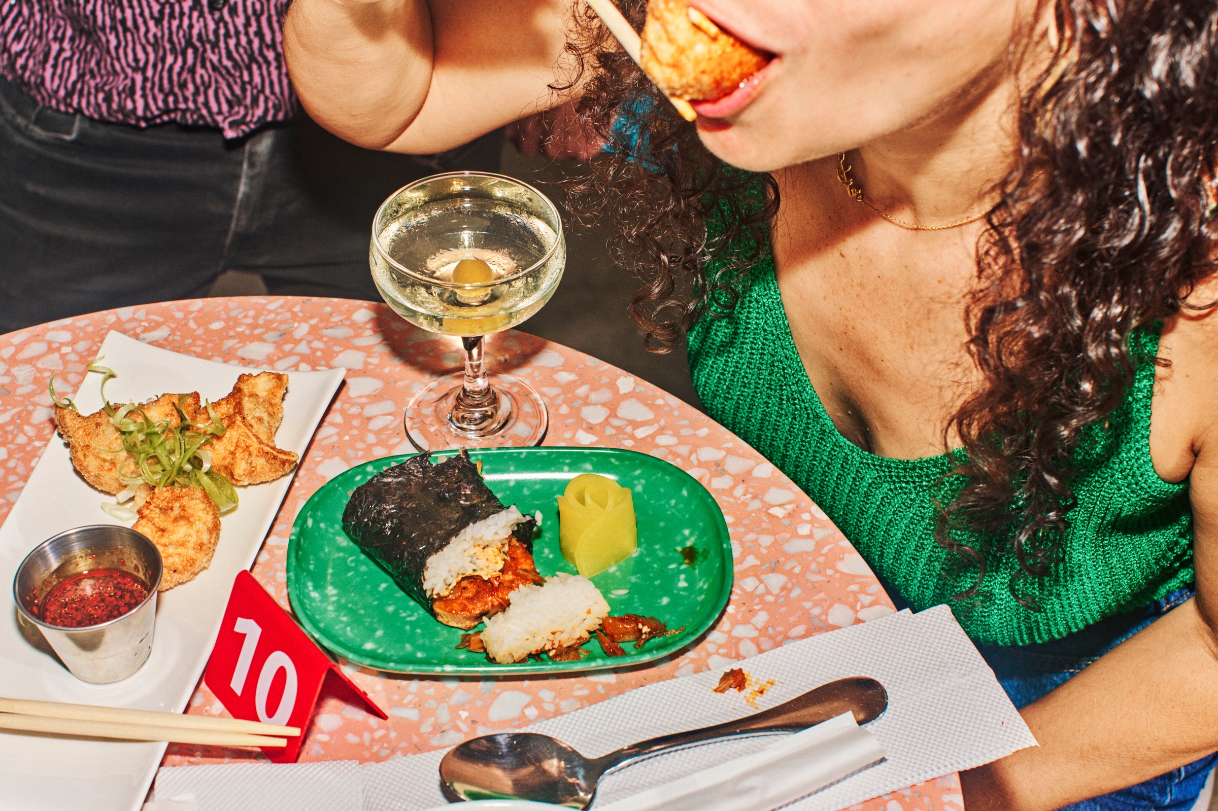A customer slurps a fried dumpling at the opening of Orion Bar in Bushwick, Brooklyn.