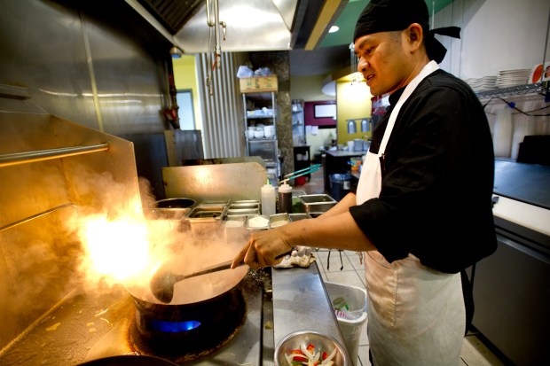 A cook prepares food in the kitchen at Aloy Thai in Boulder in 2011. Aloy is participating in Mile High Asian Food Week. (Camera file photo)