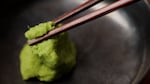 A lump of green wasabi paste with chopsticks