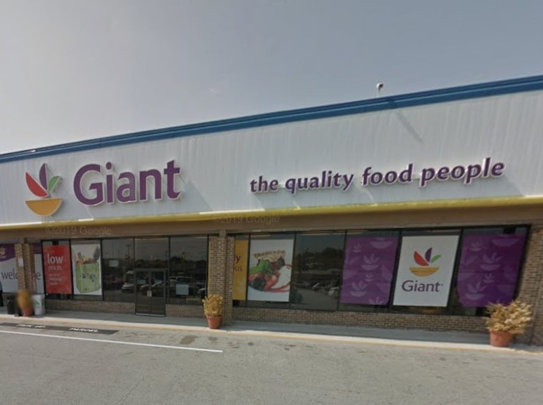 The front exterior of a Giant Food grocery store, with the "Giant" name and logo on the top of the building as well as the phrase "the quality food people."