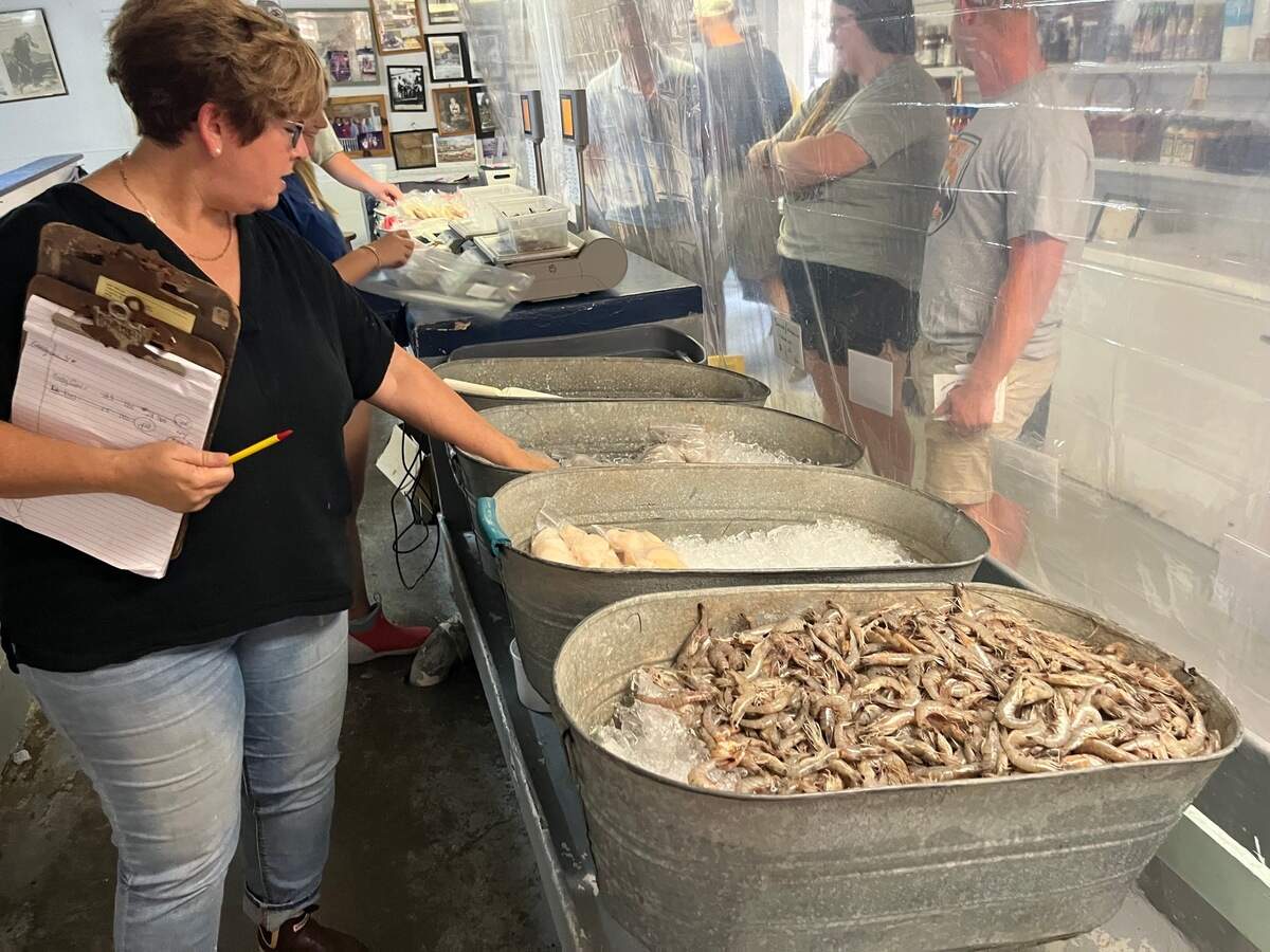 Cyndy Carr checks the display counter at Gay Fish Co. on St. Helena Island which includes fresh seafood including locally caught shrimp delivered to its docks on Ward Creek, located directly behind the retail store.