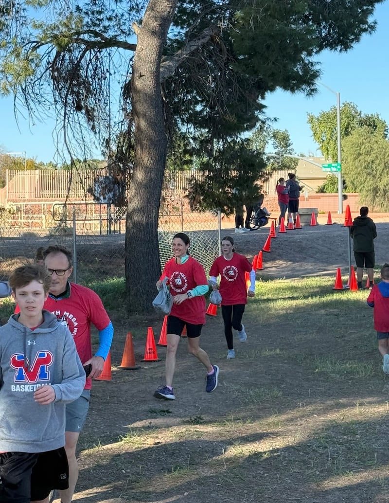 Participants run to the finish line  with grocery bags full of donated food during the second annual Northeast Mesa Grocery Run in Mesa, Arizona, on Feb. 21, 2026.