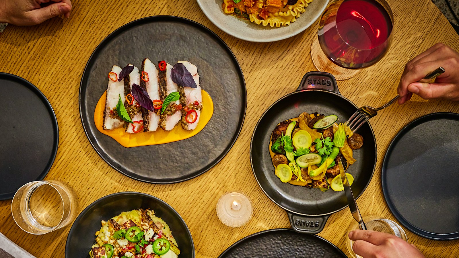 A selection of dishes with glasses of wine from Crown Shy in New York City.