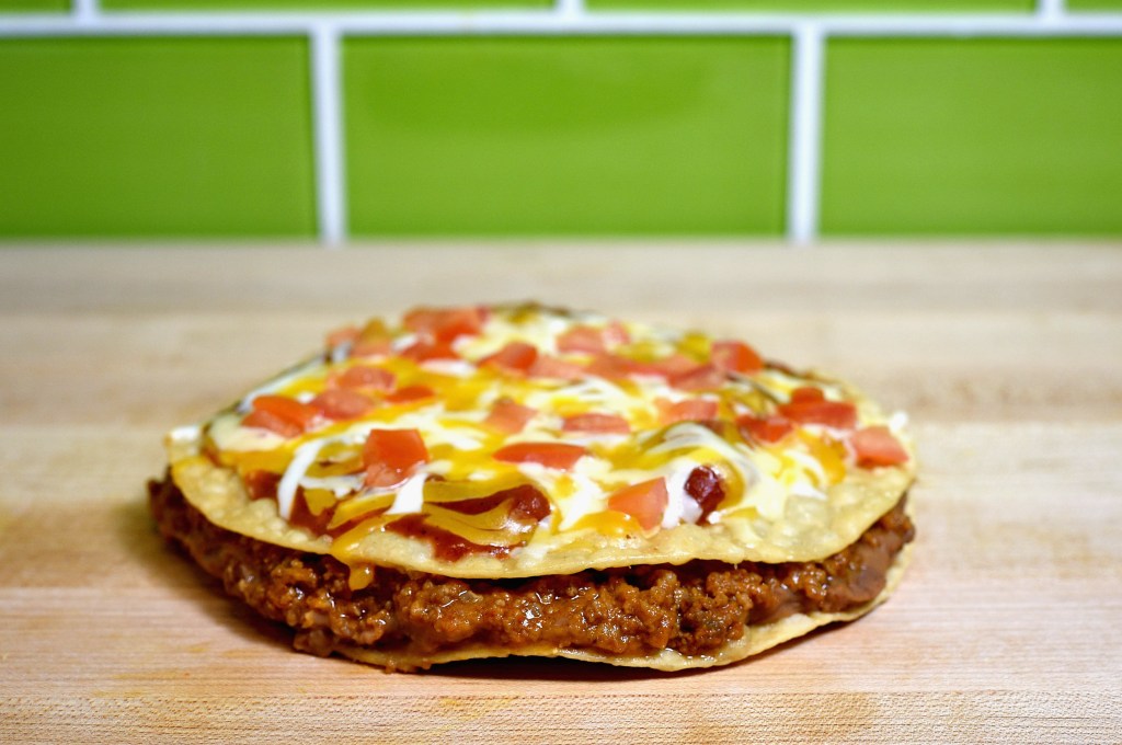 A Taco Bell Mexican Pizza on a wooden surface.