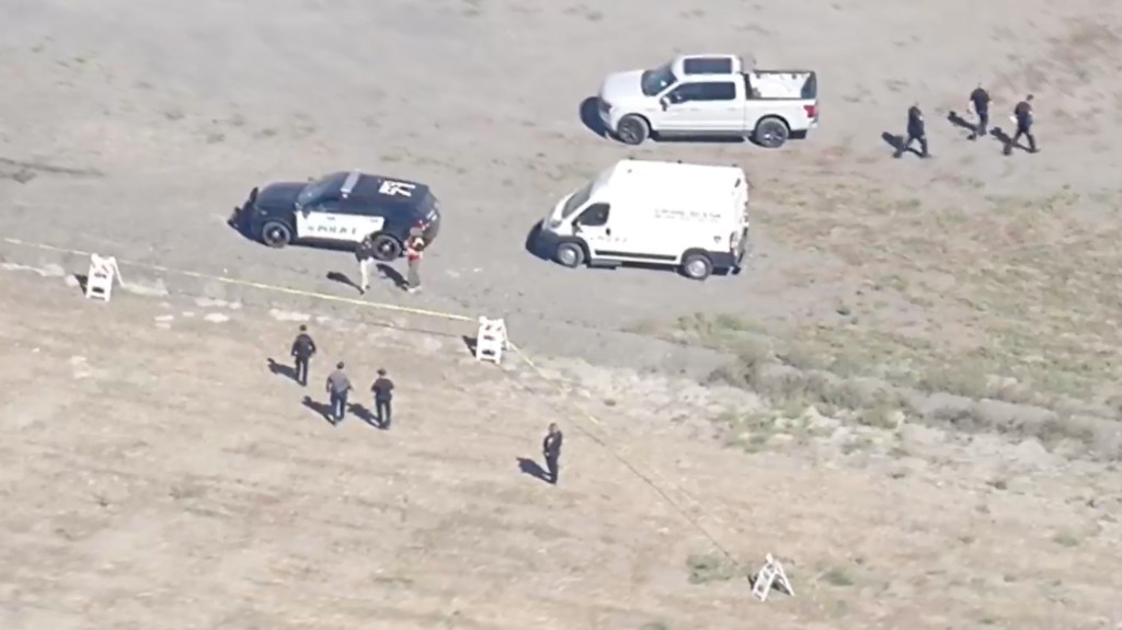 Aerial view of police and emergency vehicles at the scene of a small plane crash.