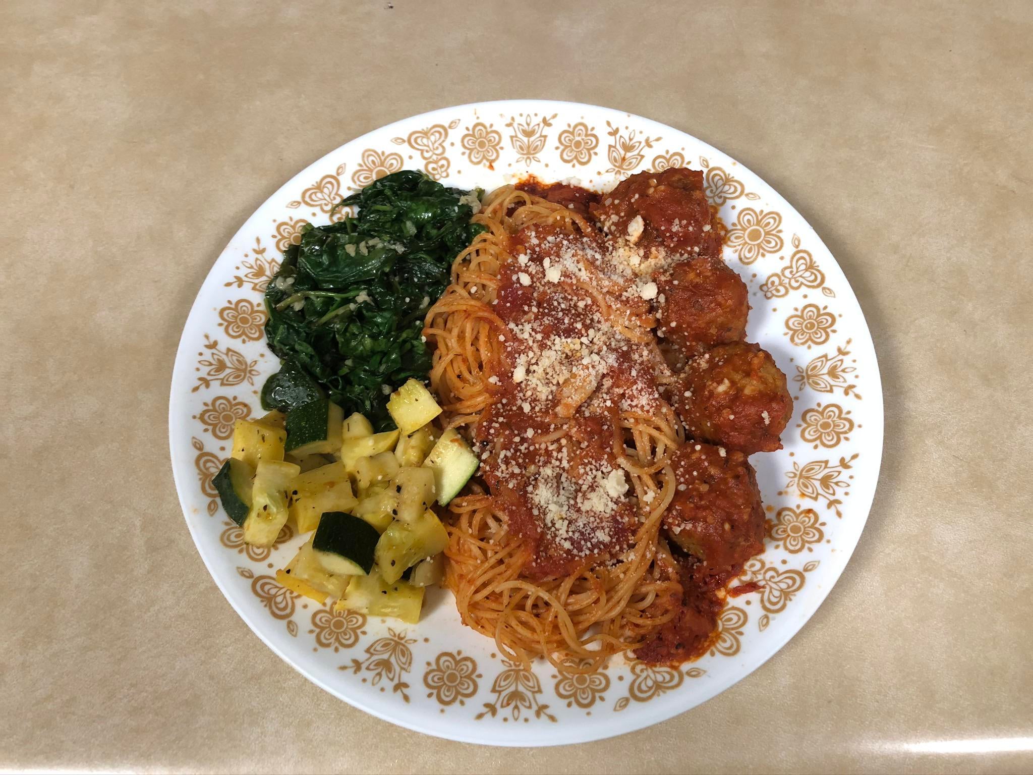 Spaghetti with homemade meatballs and sauce, sautéed spinach and
