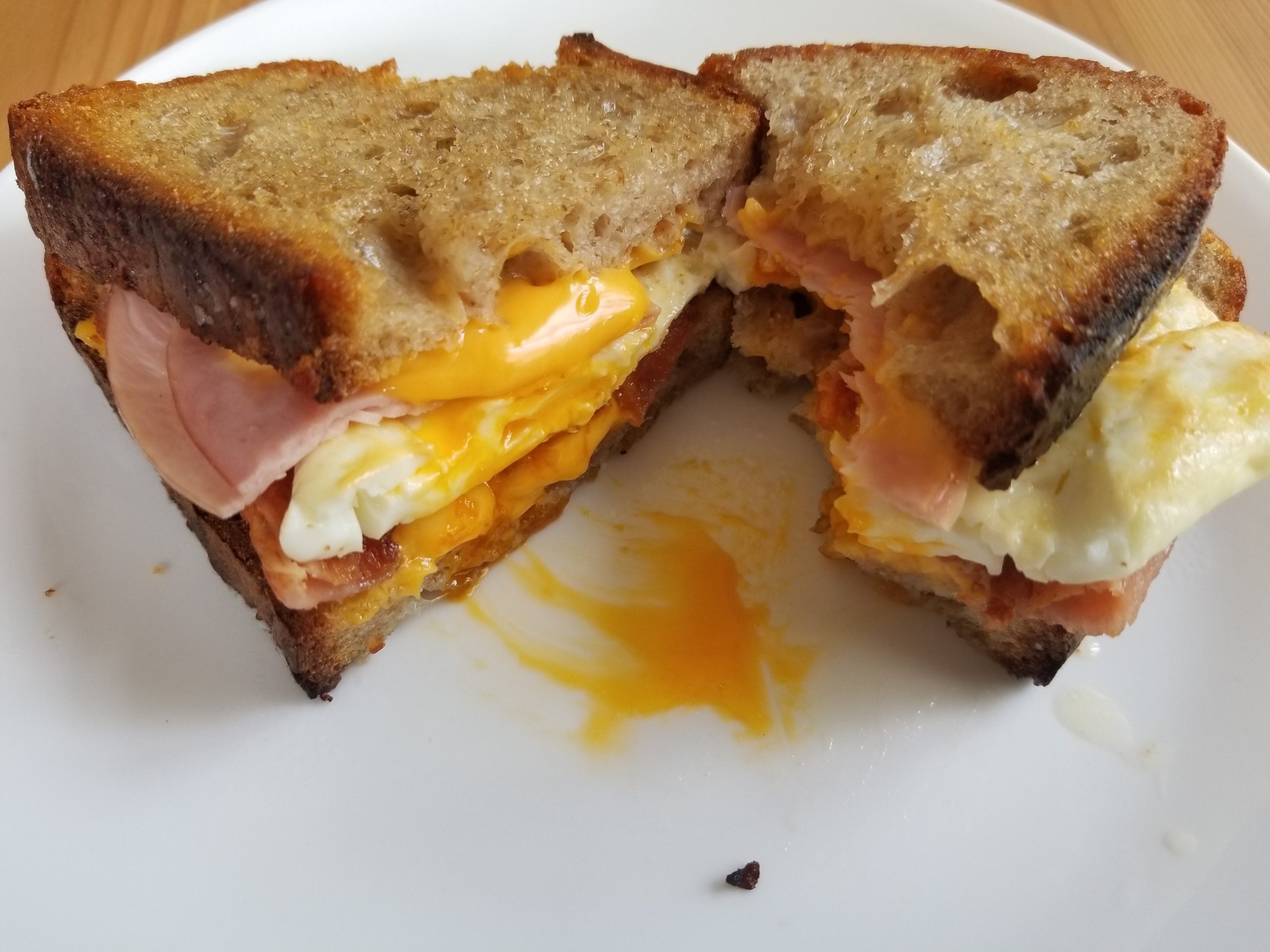 Bacon, Over Easy Egg, Ham, and American "Cheese" on ButterToasted