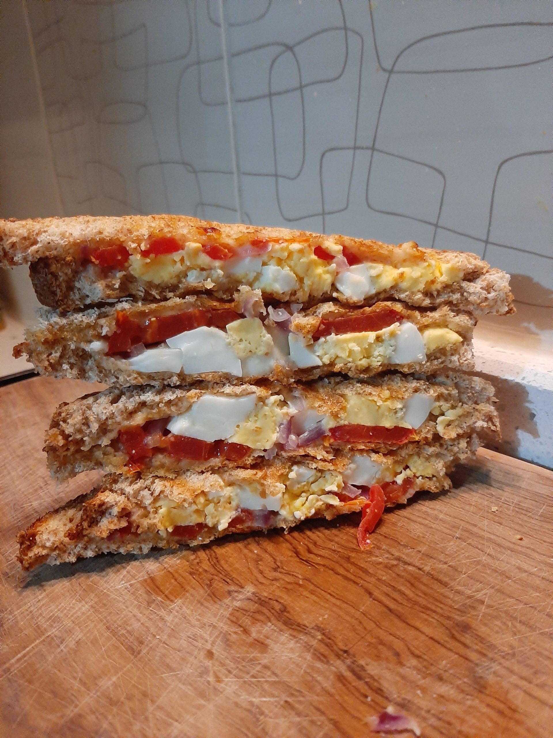 Cross section of egg sandwiches with egg tomato onion and parmesan