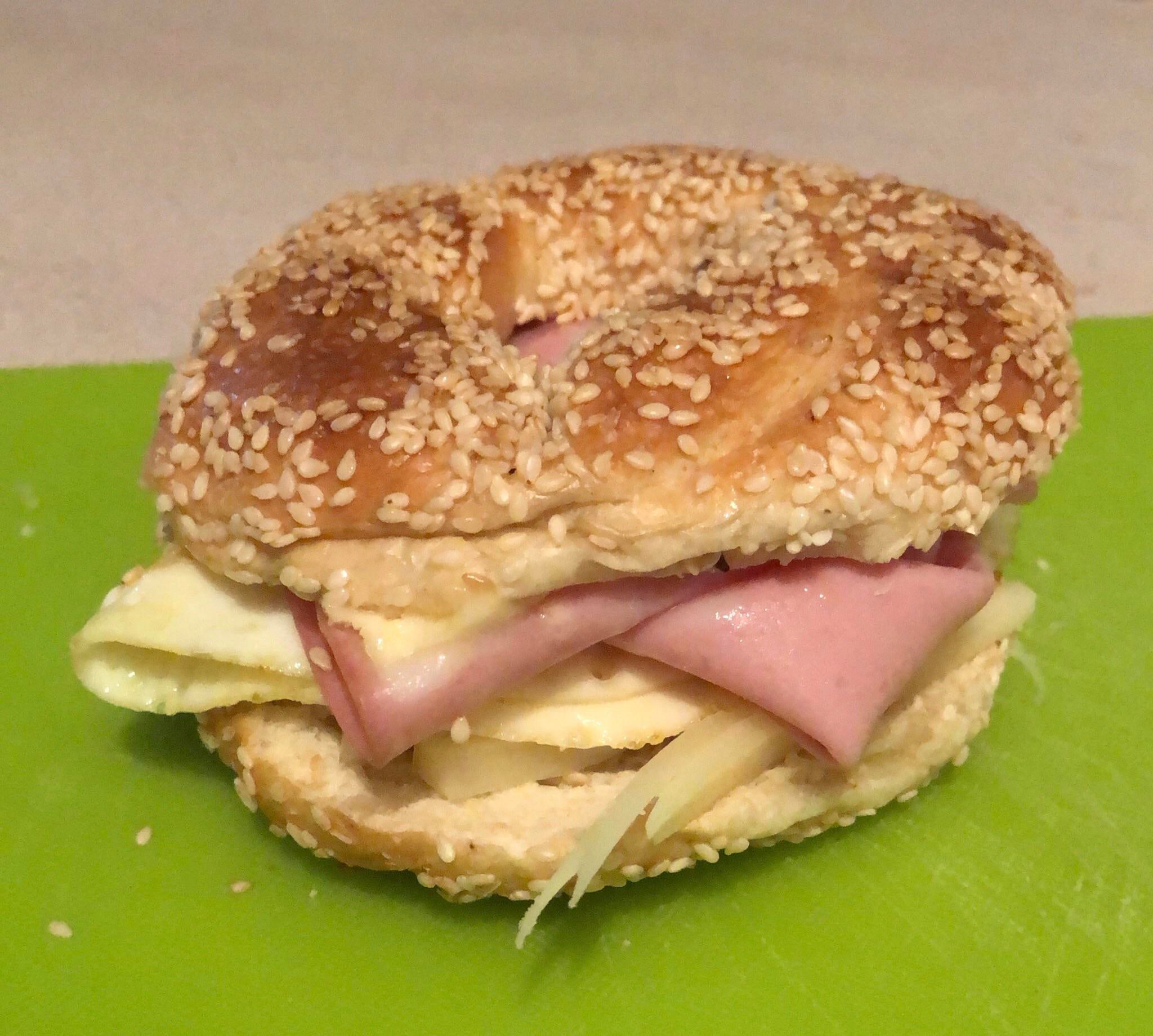 Tasty bagel sandwich with mortadella, provolone, butter and a fried egg