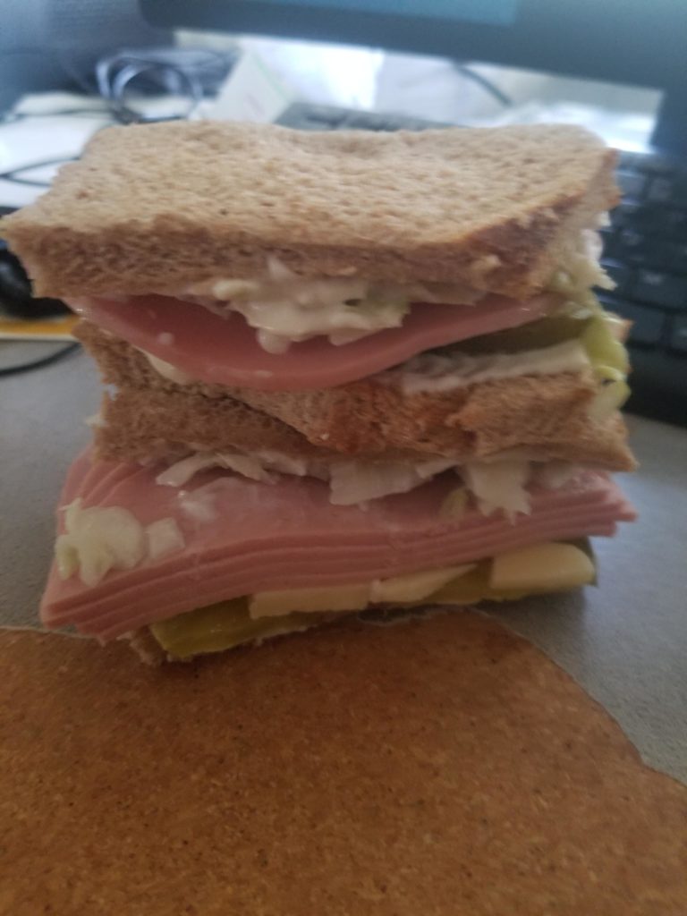 The most ultra deluxe bologna sandwich I've ever made w/coleslaw, mayo, dill pickle slices, extra sharp white cheddar, on wheat with the crusts cut off.