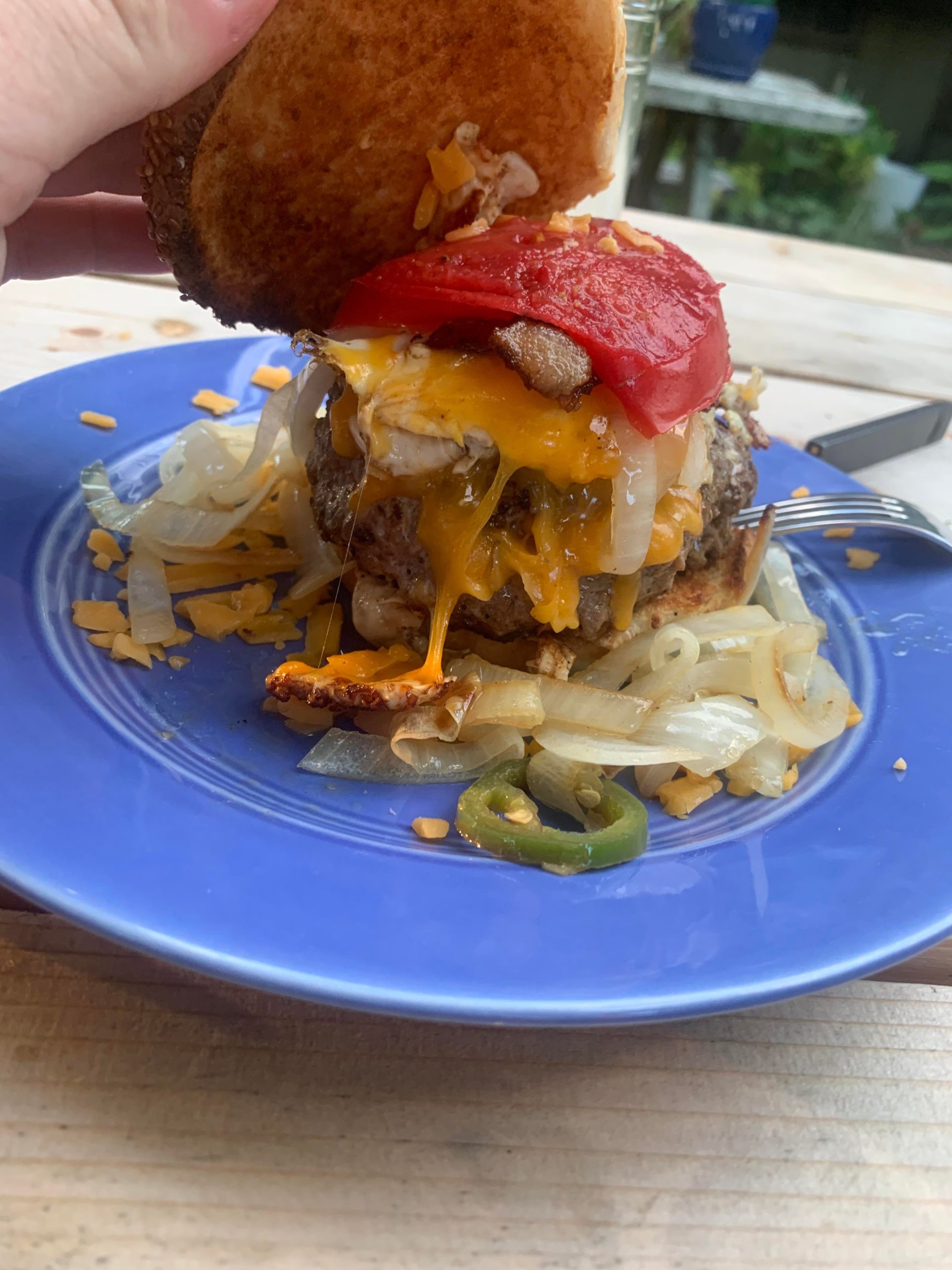 Halfpound patty, sautéed onion and jalapeño, cheddar, and tomato, on a