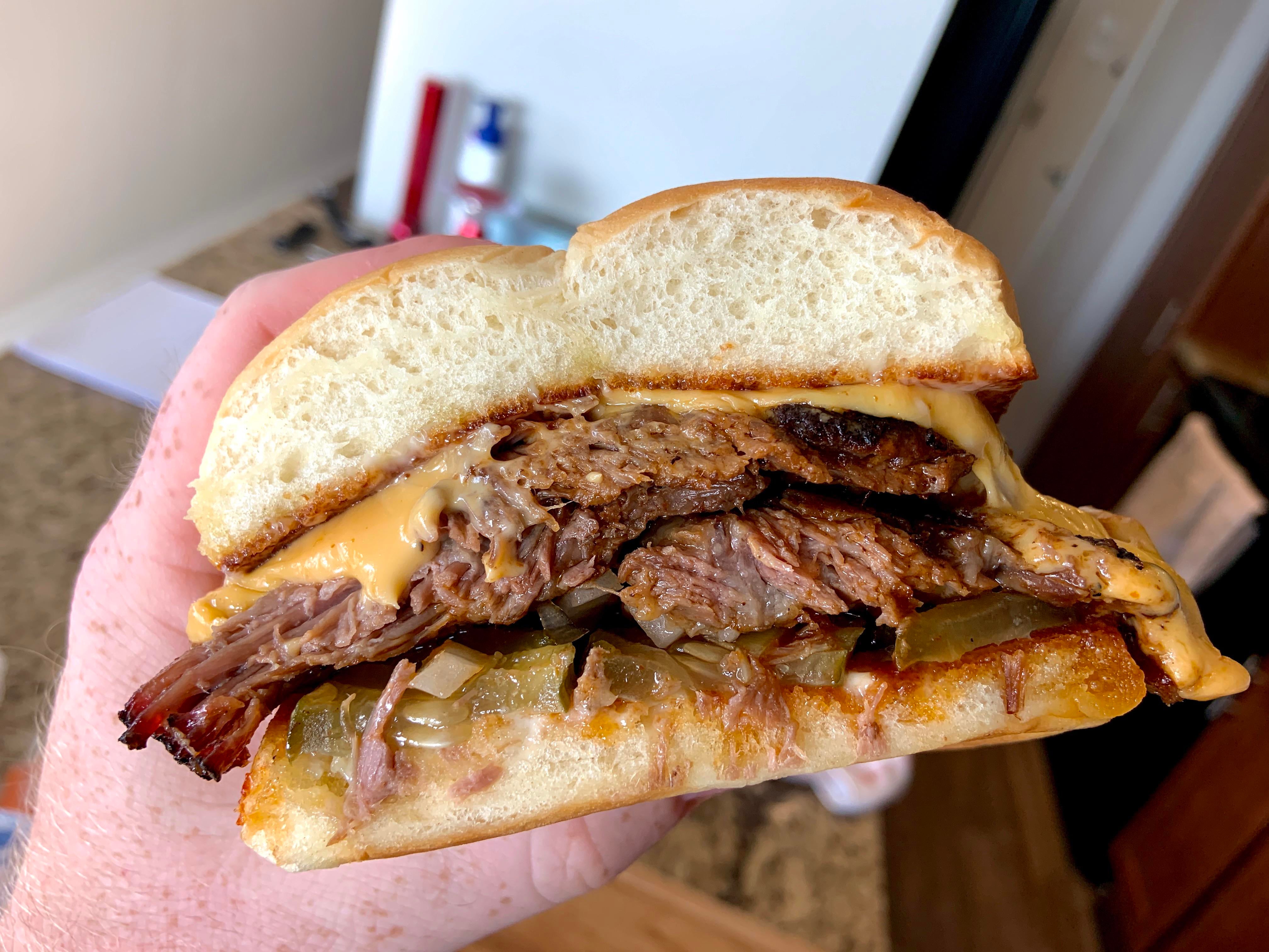 Leftover fatty brisket sandwich with cheese, onions and spicy pickles