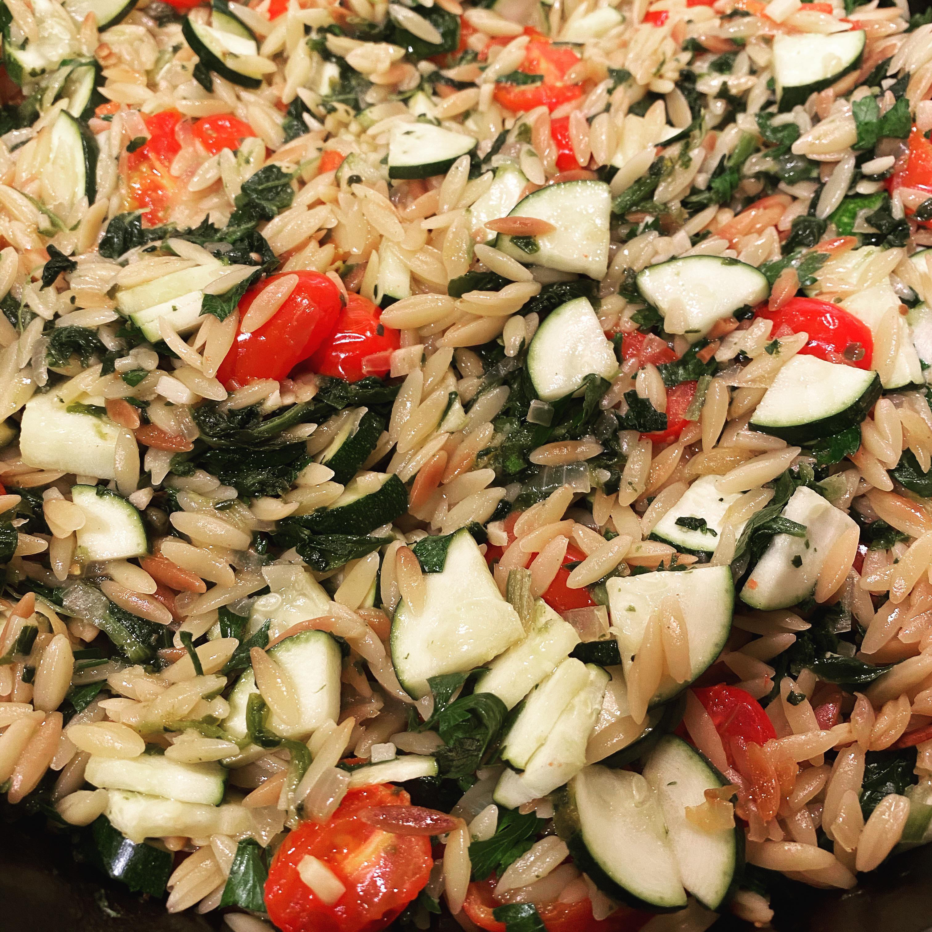 Skillet baked orzo with zucchini, grape tomatoes, and spinach. Dining