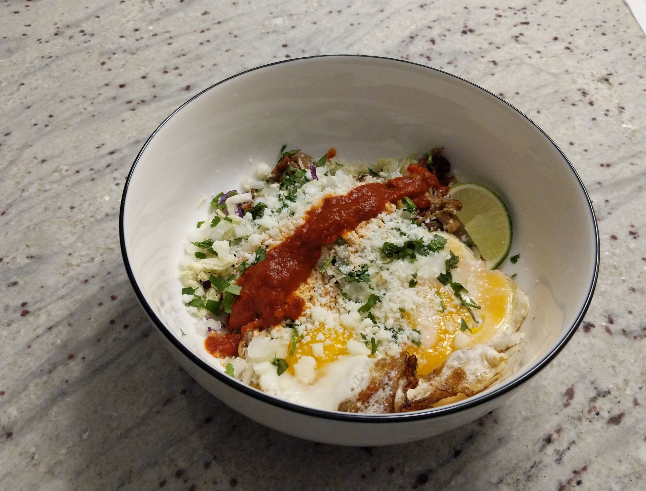 Carnitas, 2 fried eggs, cotija cheese, shredded cabbage, diced onion