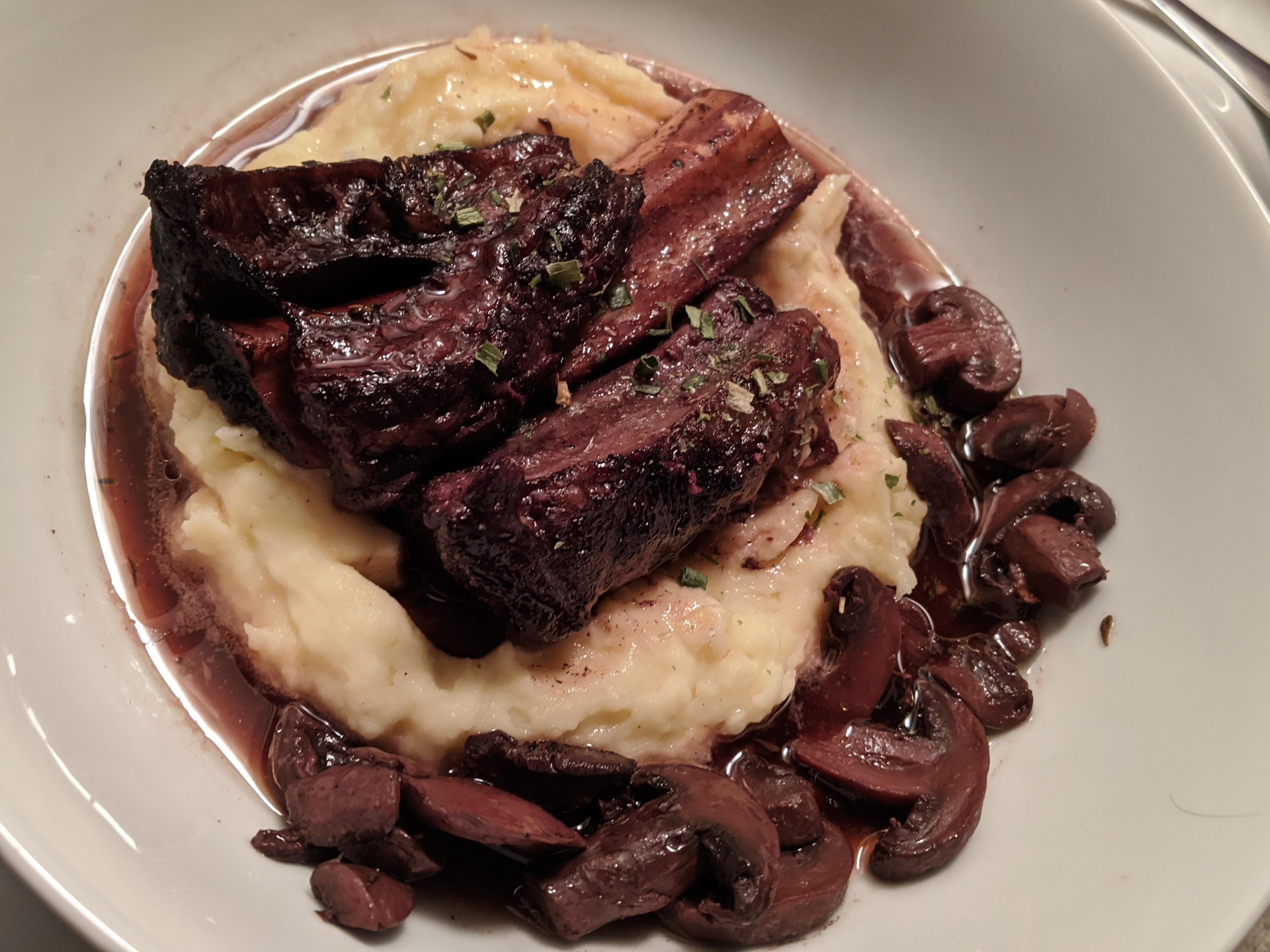 Slow cooked beef short ribs over mashed yellow potatoes bedazzled with