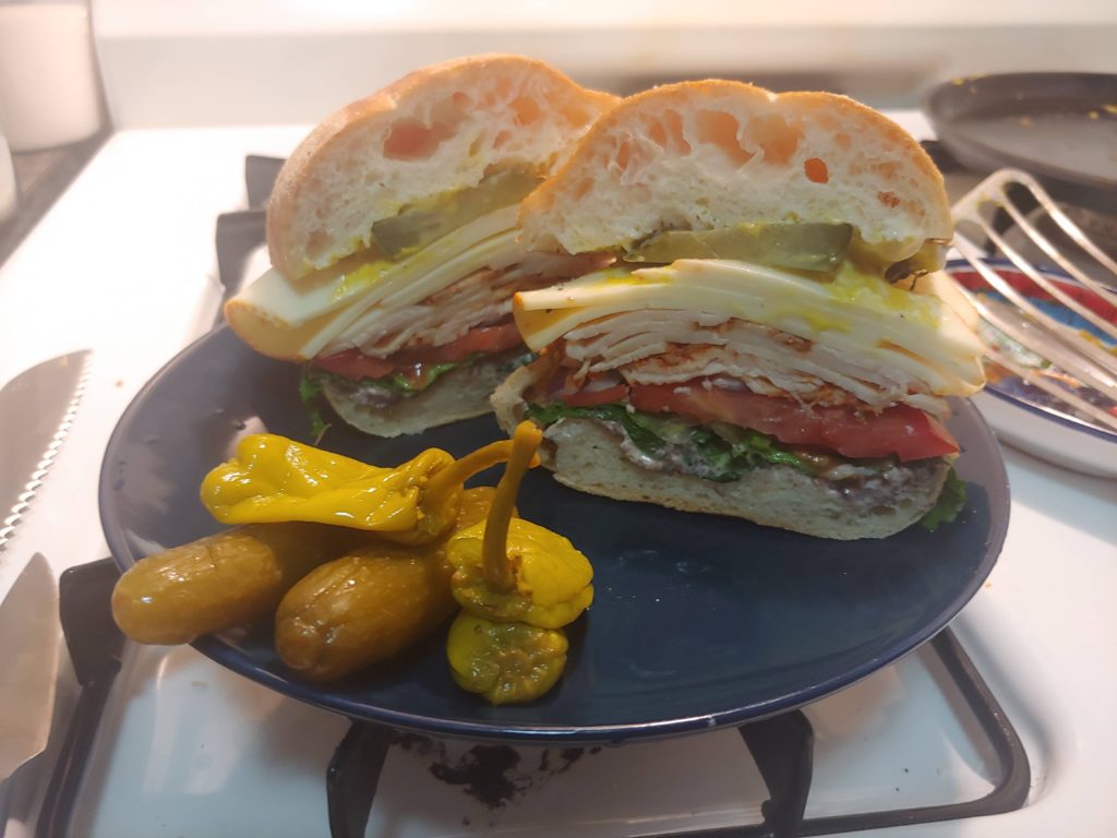 Sausalito turkey, muenster, tapenade, mayo, mustard, LTO, pickles, on a portuguese roll