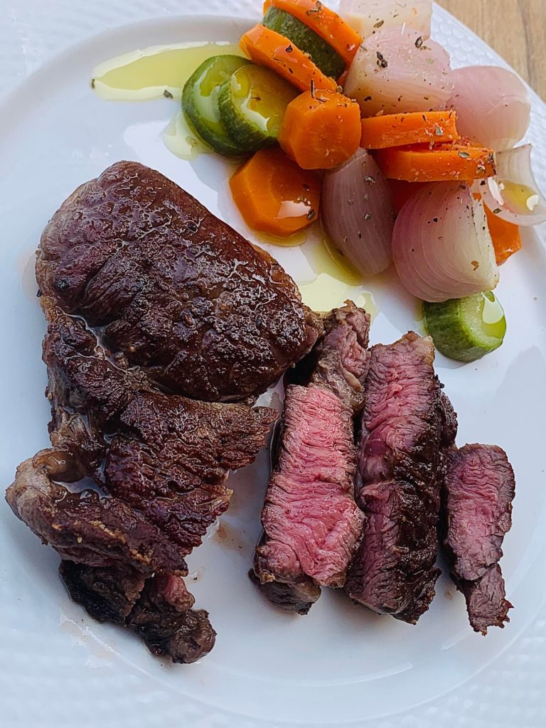 Basted Black Angus Cube Roll and a glass of red wine for lunch.