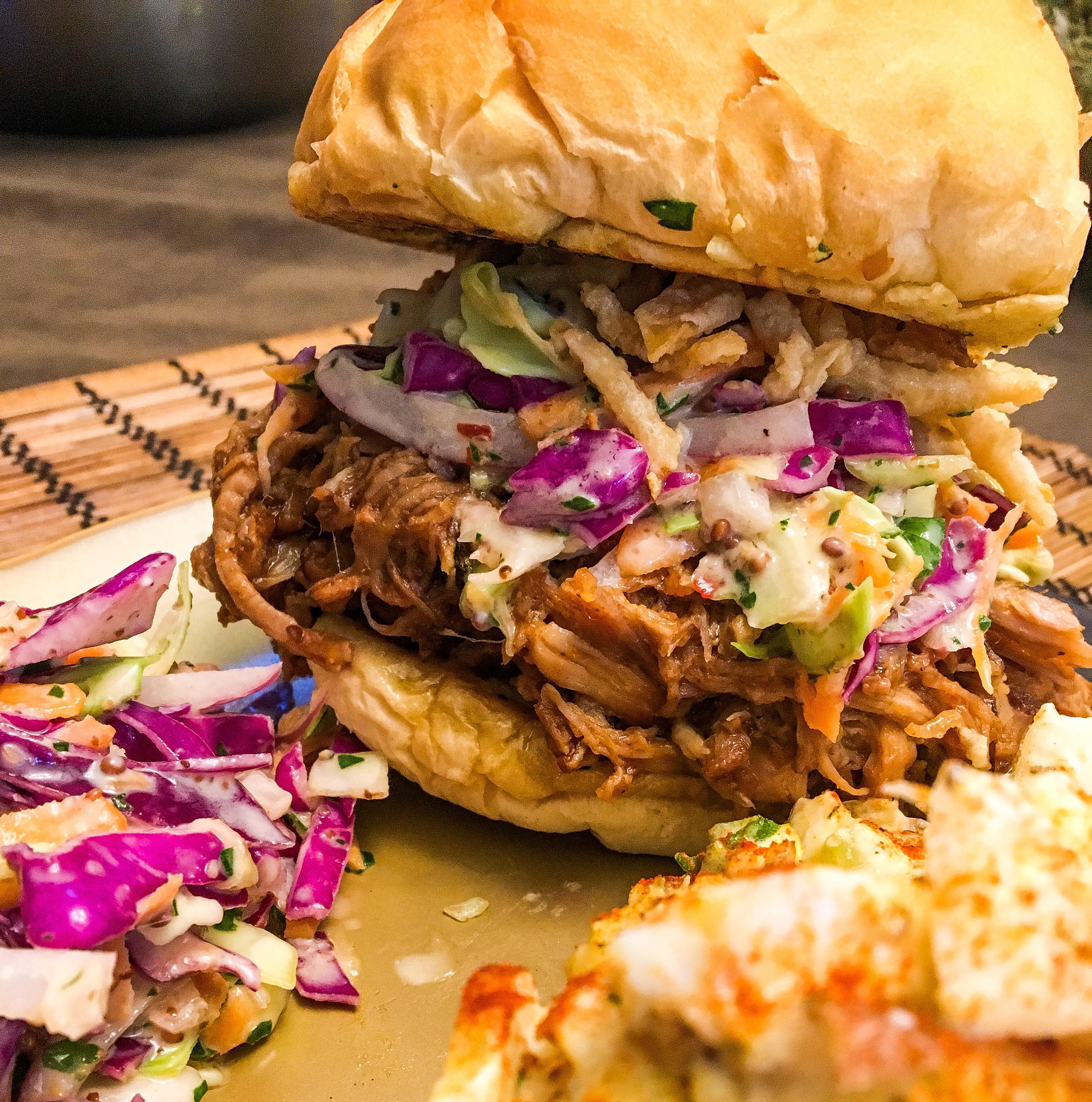 BBQ Pulled pork, homemade tangy coleslaw, crispy onion strings, garlic butter toasted Kaiser 