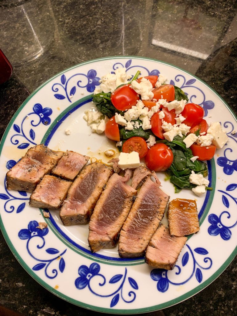 Seared tuna steak with a side of spinach, tomato and feta cheese