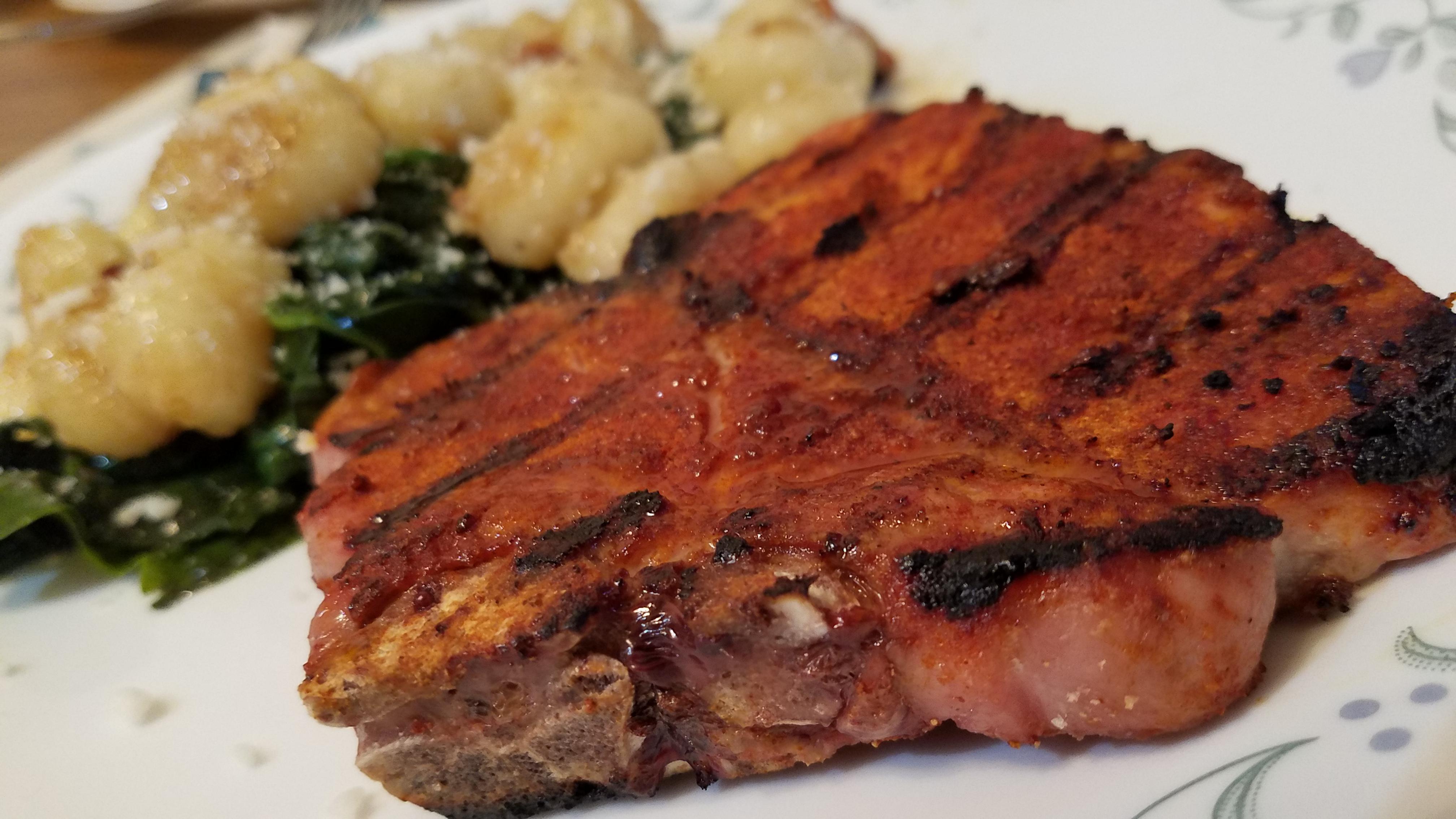 Homemade grilled pork chop with gnocchi and spinach sauteed in garlic and olive oil Dining and