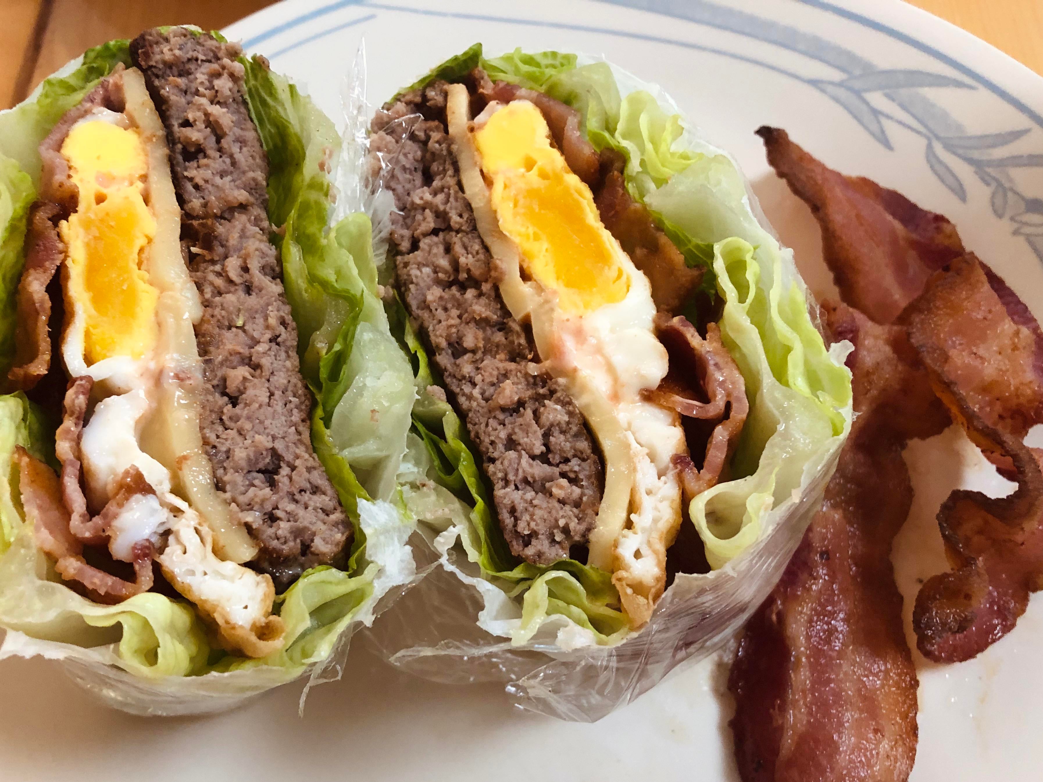 Lettuce wrapped bacon, egg, and Gouda cheese angus burger with a side