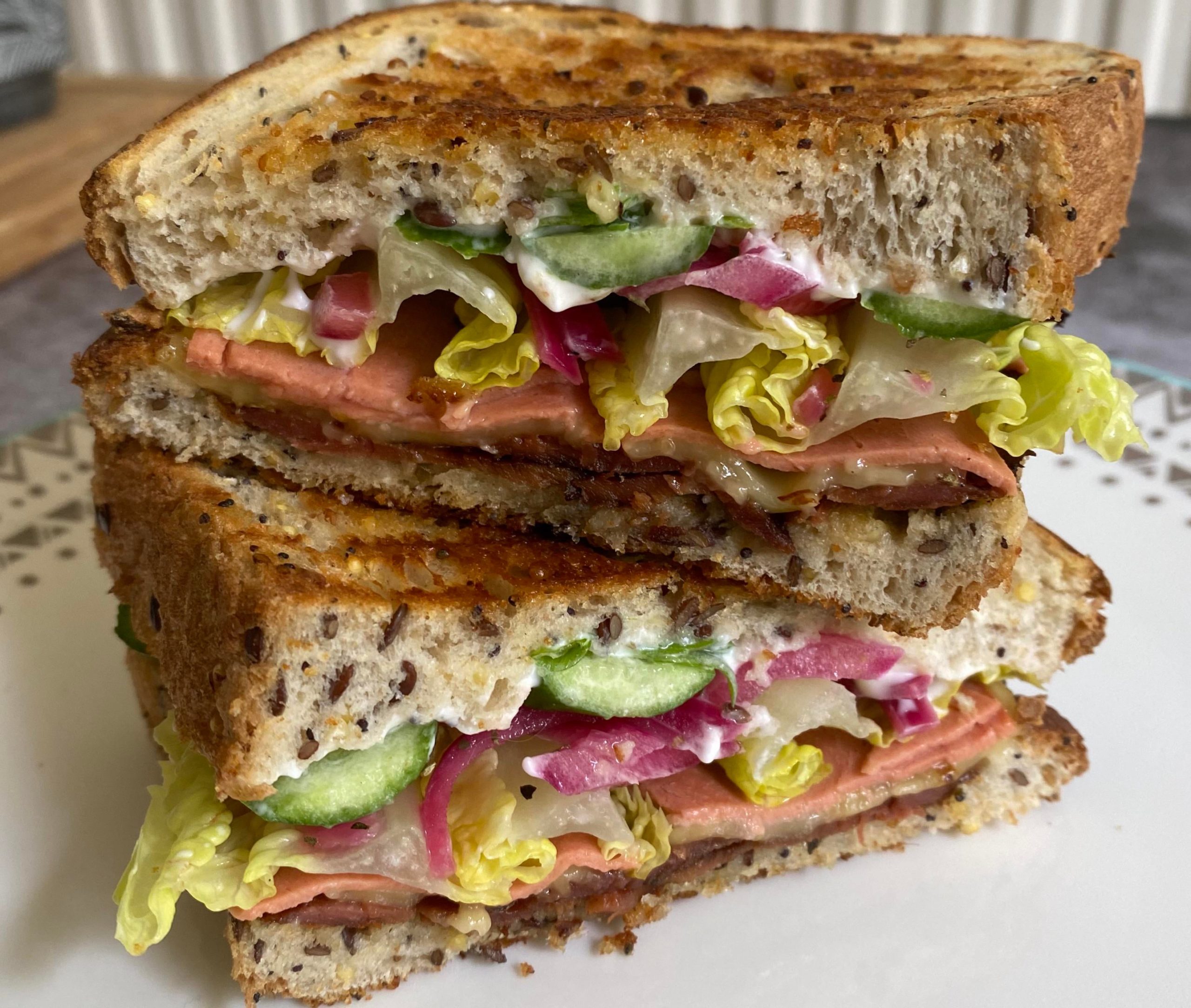 Sandwich with vegan bacon and cheese, pickled red onions, lettuce