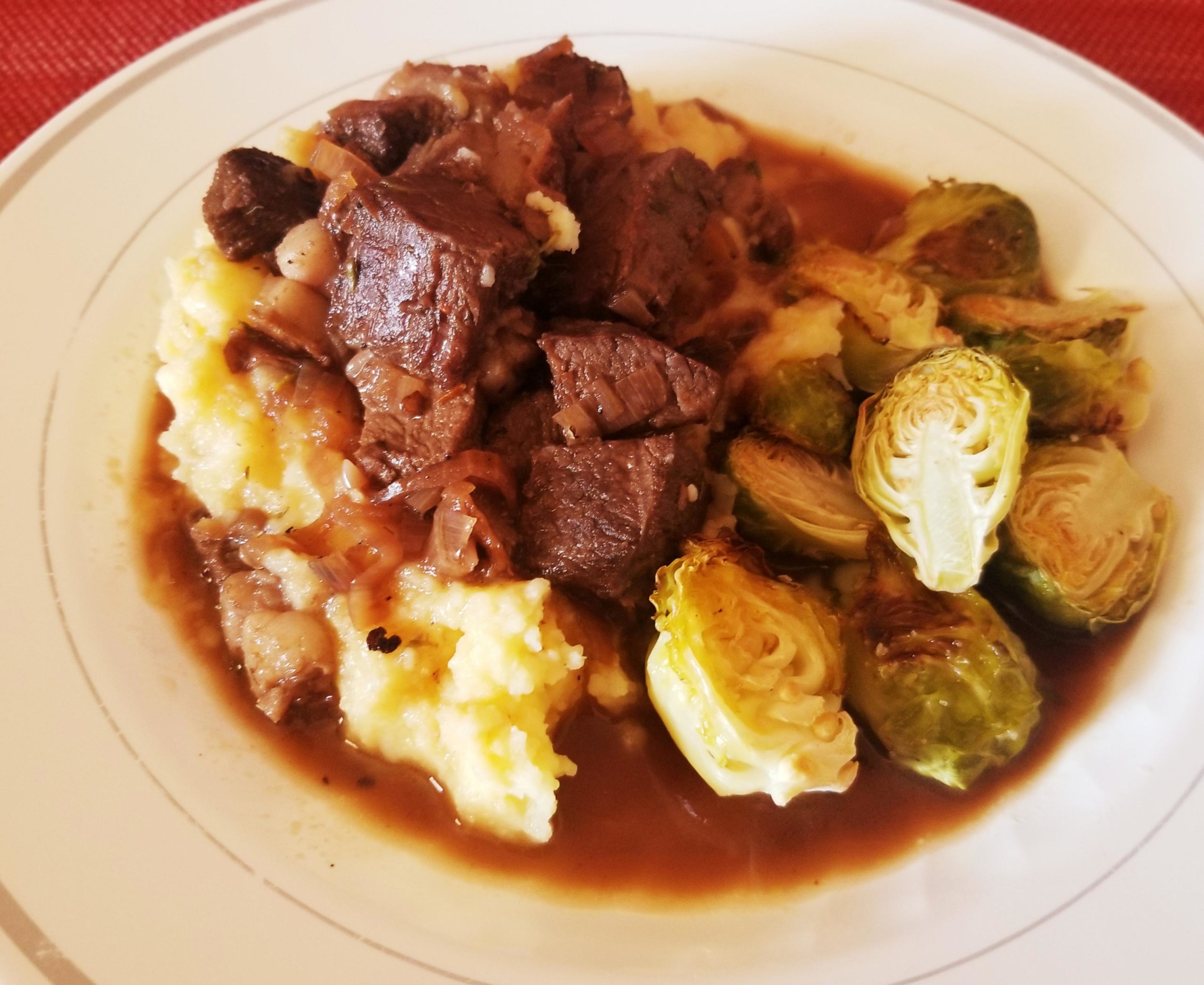 Beef tips in a red wine and shallot gravy with roasted brussel sprouts