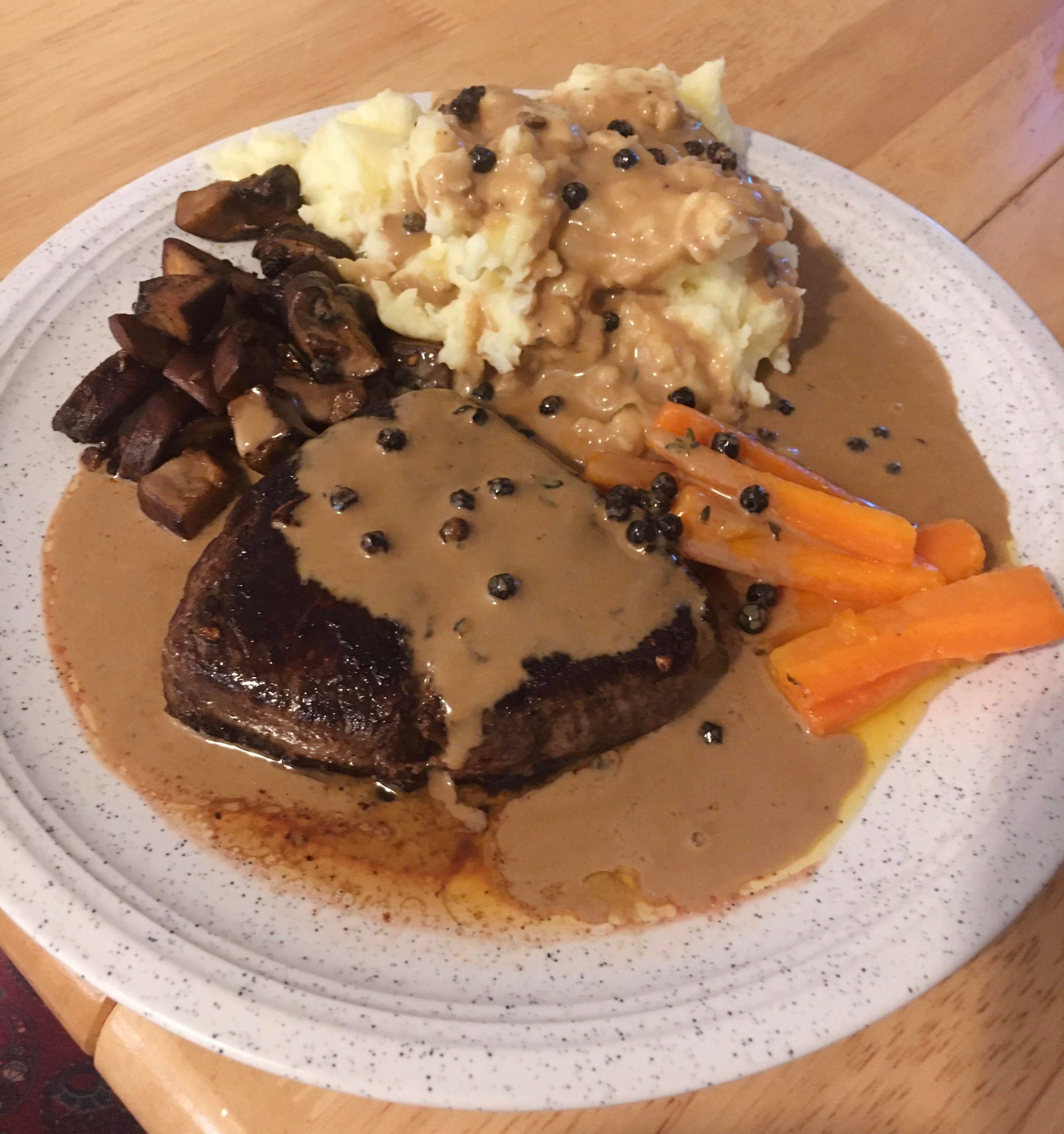 Steak with homemade peppercorn sauce, garlic mushrooms, creamy mashed
