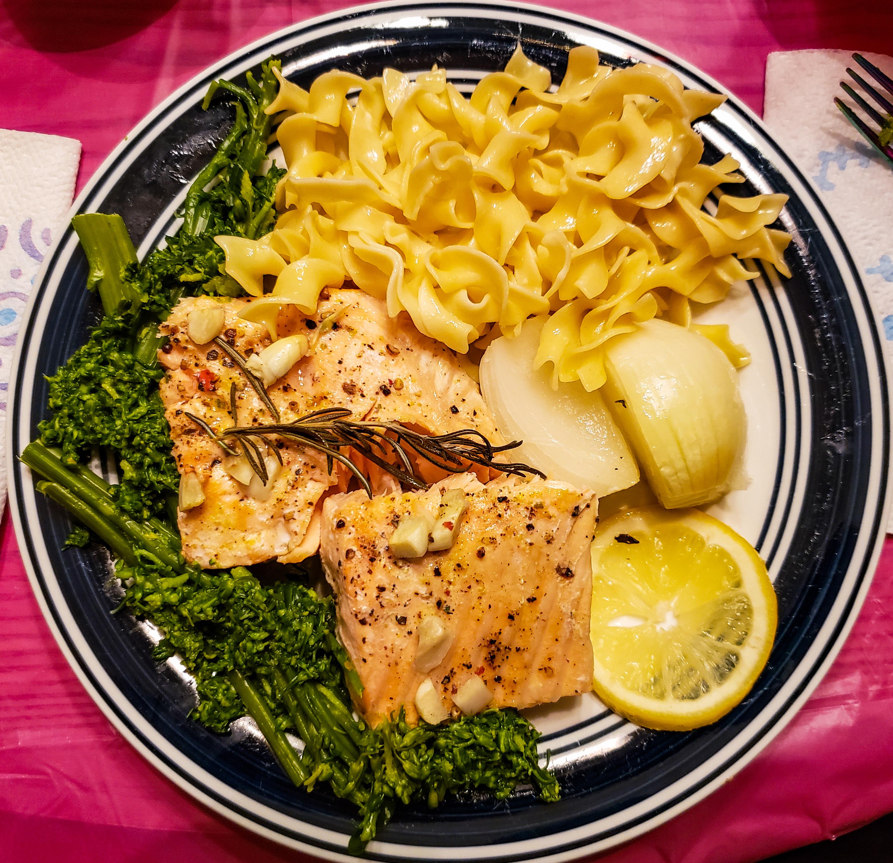 Baked salmon with garlic, onions, lemon, egg noodles, and broccolini