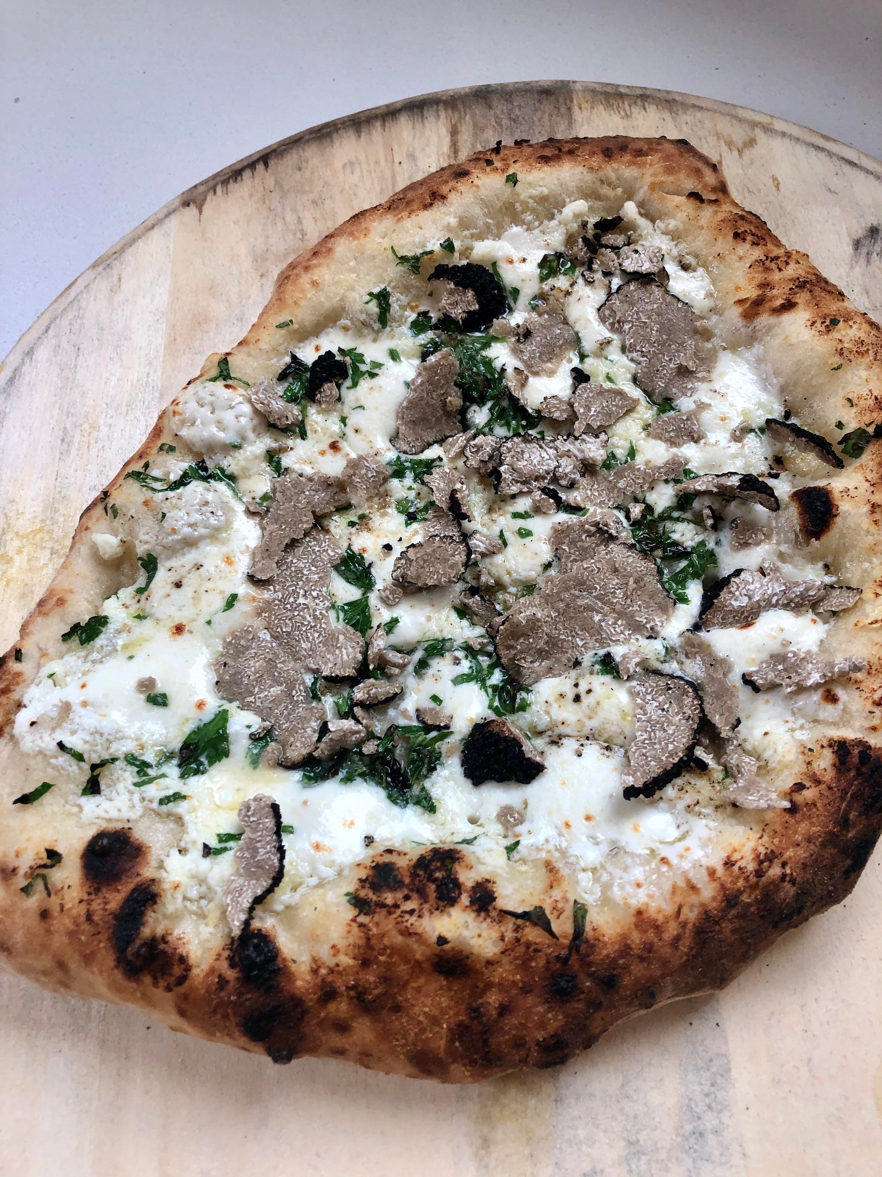 White pizza with freshly shaved black summer truffles. A poor ...