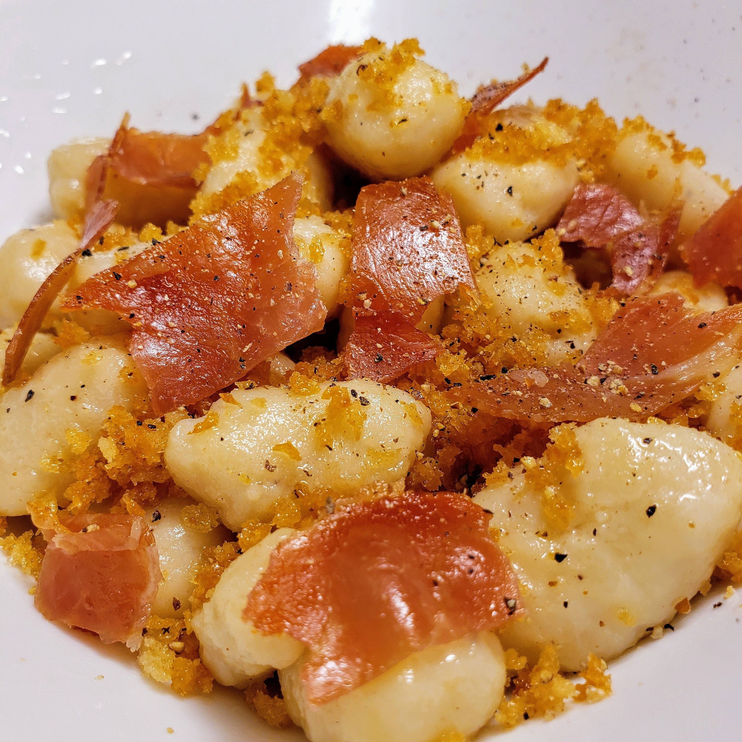 Homemade goat cheese gnocchi with crisped prosciutto and toasted