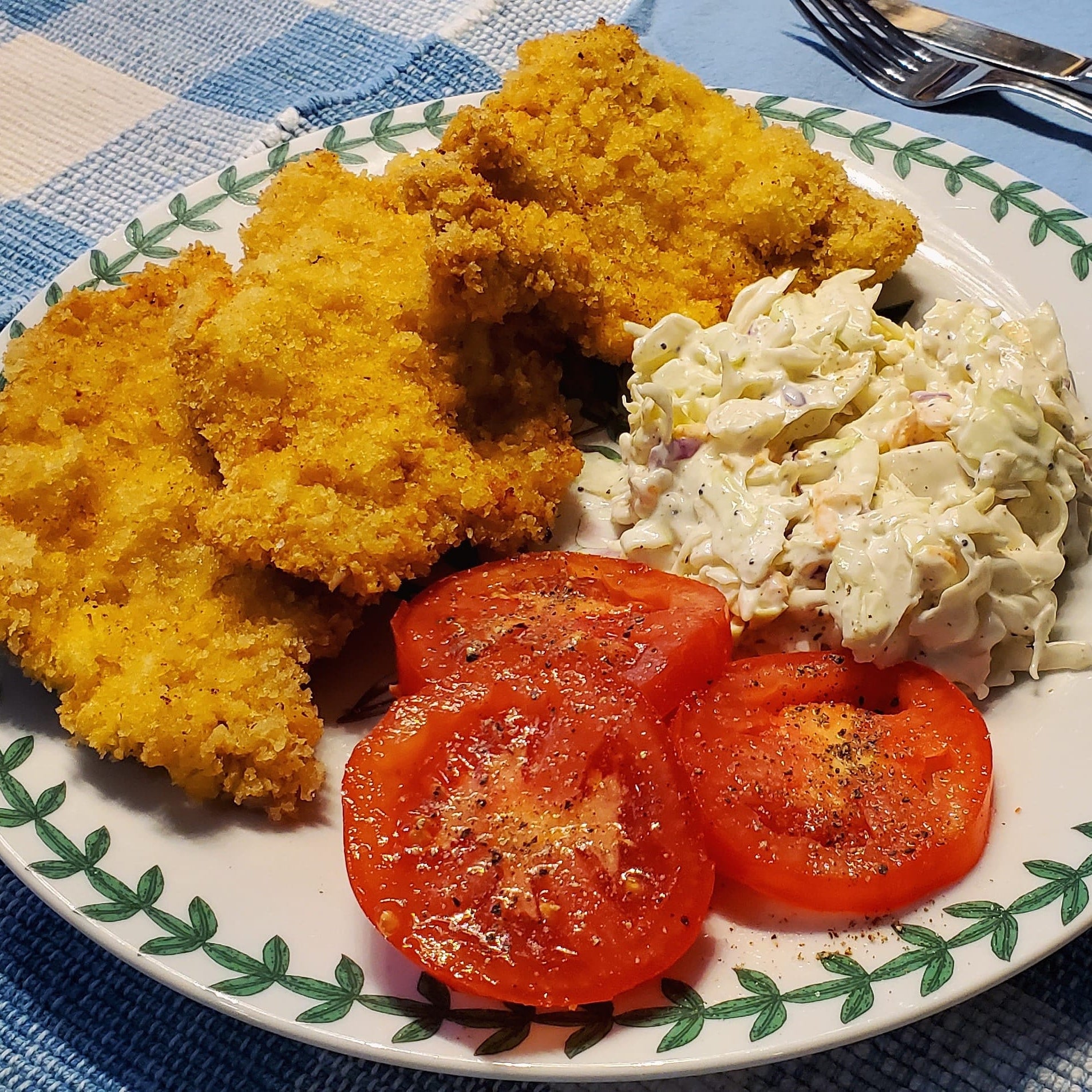 Ridiculously crispy panko crusted pork schnitzel with creamy coleslaw and garden tomatoes