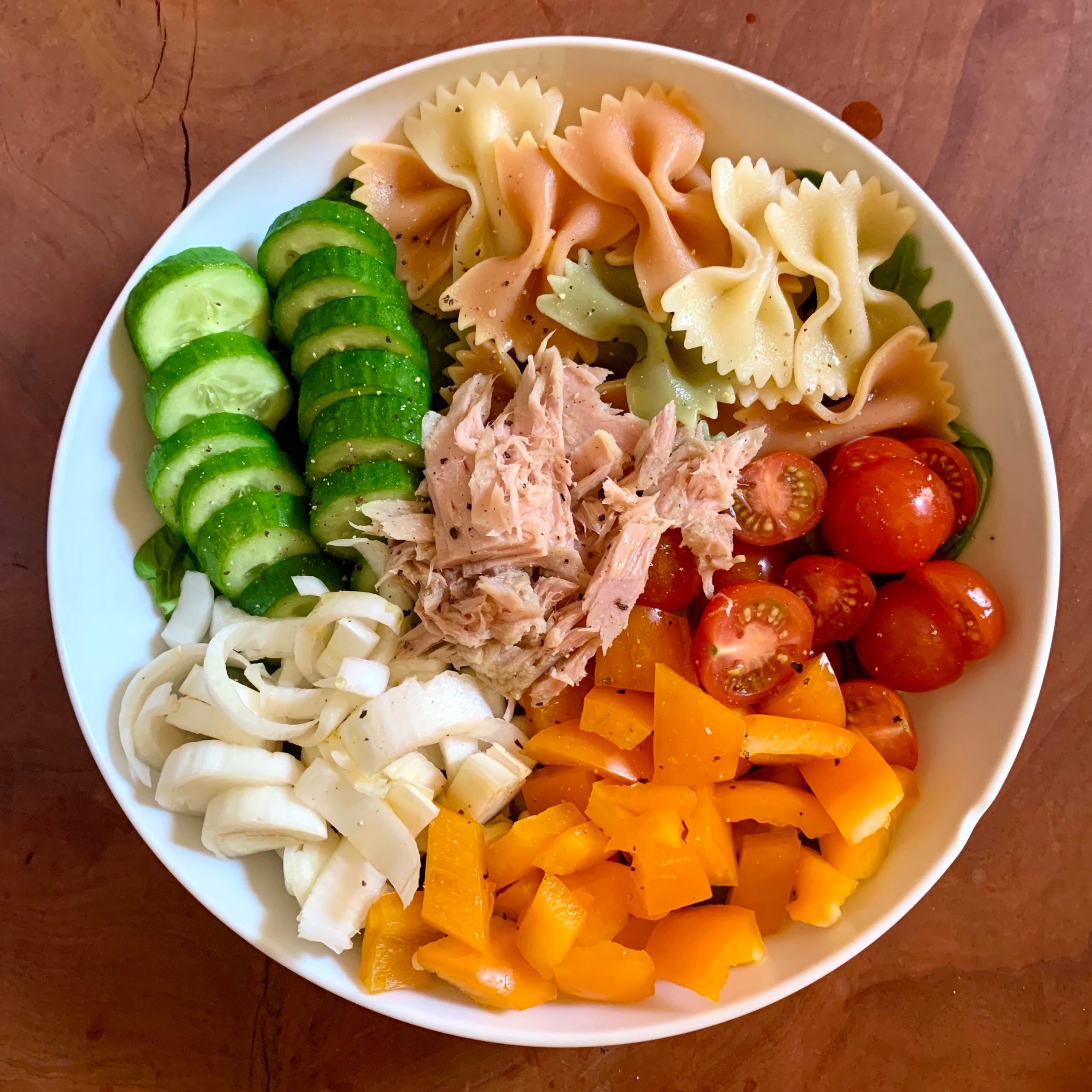 Pasta salad with cucumbers, tomatoes, endive, bell pepper, tuna in