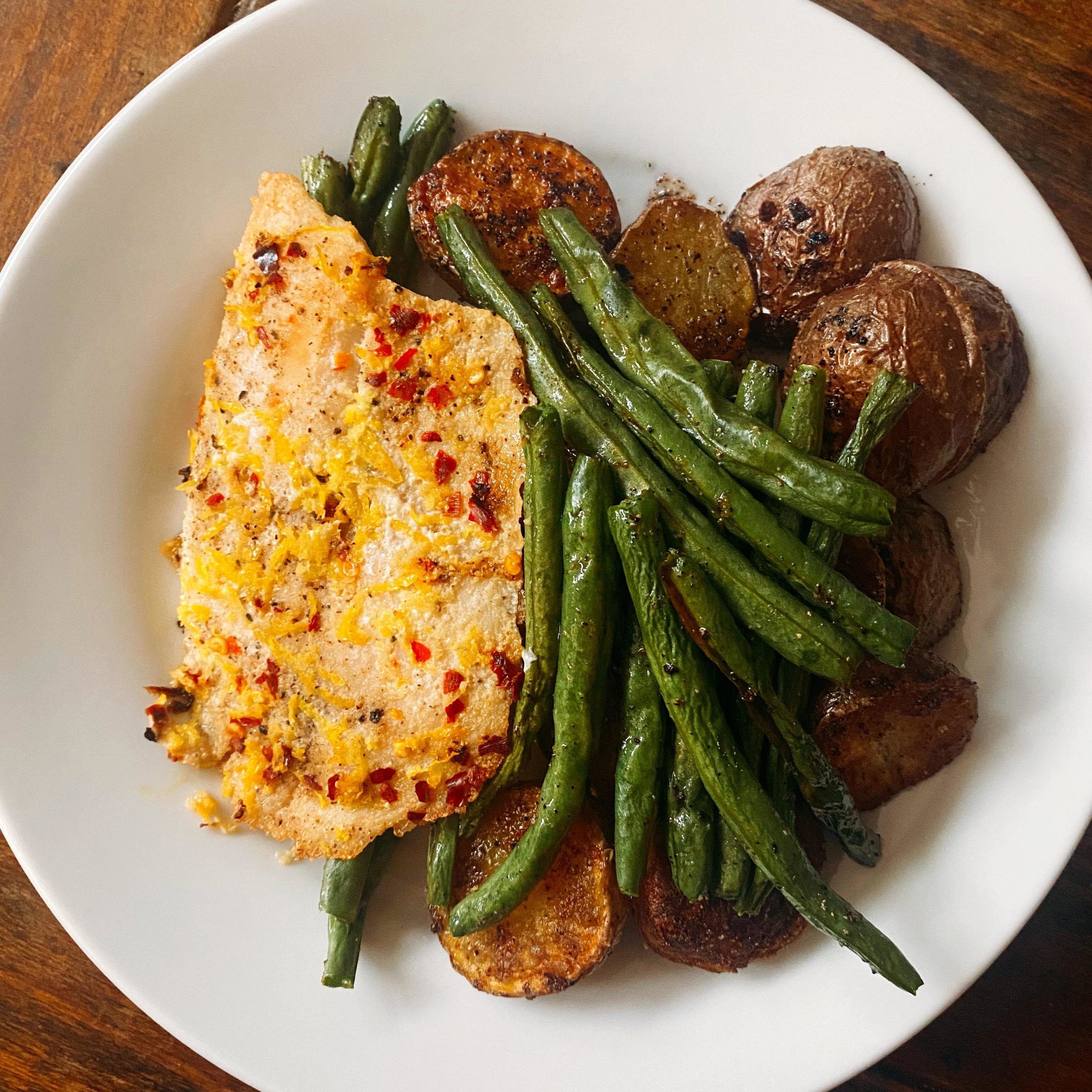 Baked lemon zest and red pepper tilapia with roasted potatoes and green