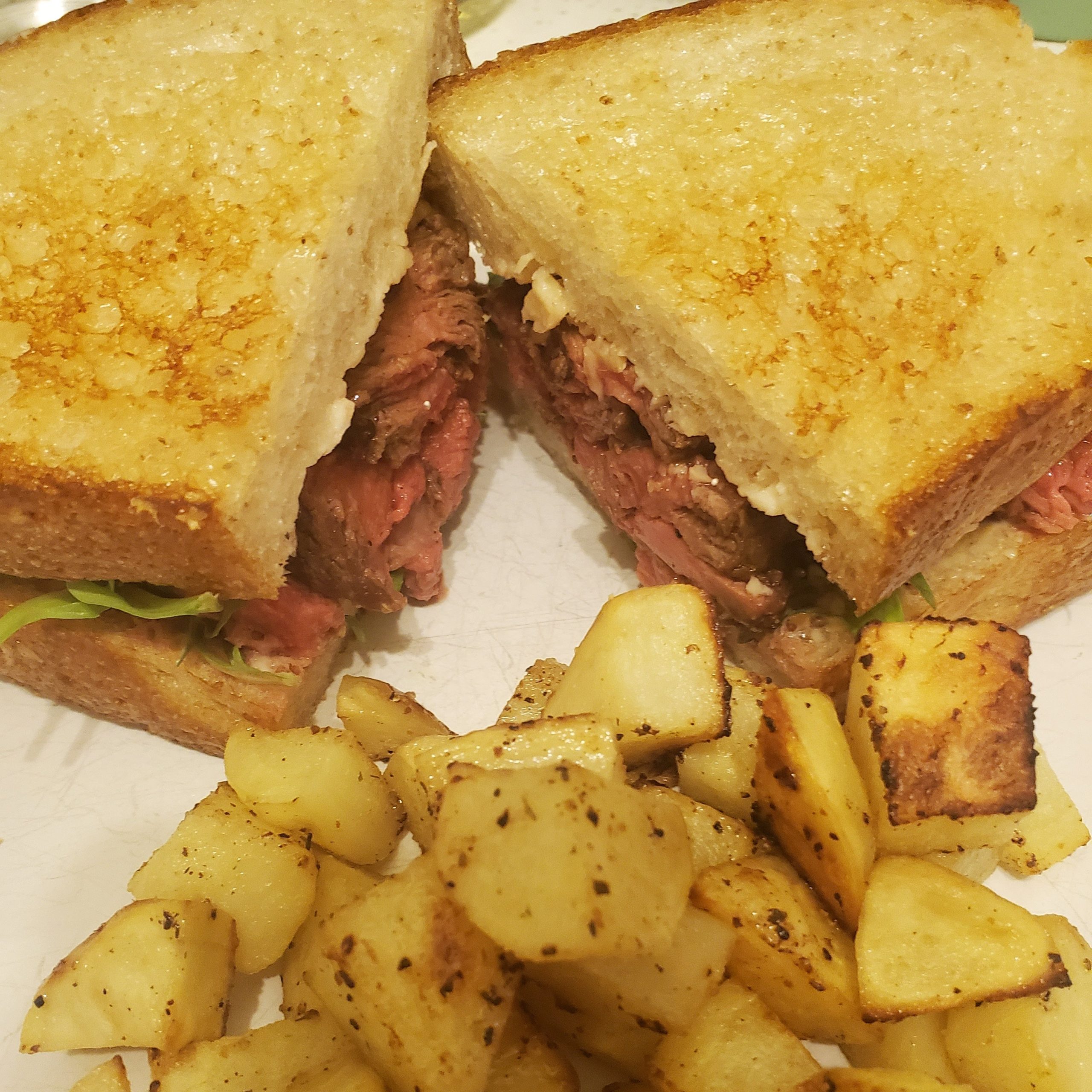 Steak sandwich with sourdough, arugula, mayo, stone ground mustard, and black pepper asiago. My